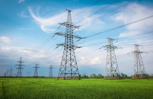 high-voltage-lines-power-pylons-flat-green-agricultural-landscape-sunny-day-with-clouds-blue-sky-cloudy-rainy-wheat-is-growing_221513-5285